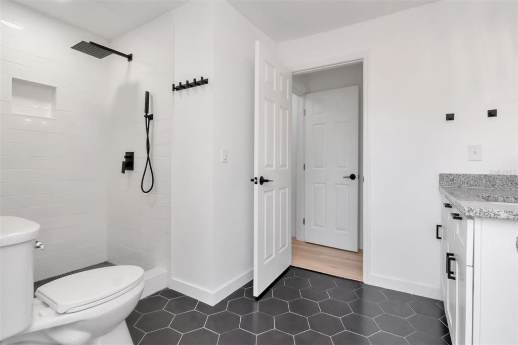 7148 Ramor Lane New Port Richey, FL 34653 - Photo 14 of 26 a bathroom with a granite countertop toilet and a sink