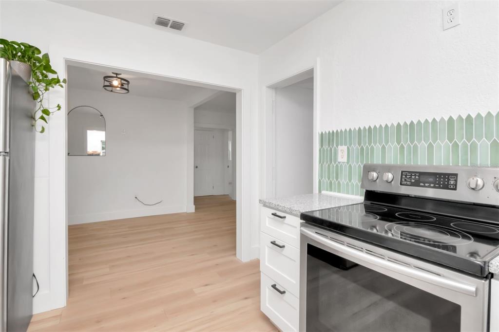 7148 Ramor Lane New Port Richey, FL 34653 - Photo 7 of 26 a kitchen with a stove and a wooden floor