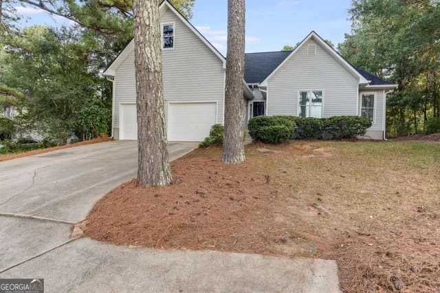 a view of a house with a yard and large tree