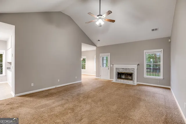 a view of an empty room with a fireplace and a window