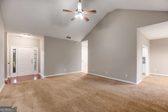 a view of a big room with a ceiling fan and a bathroom