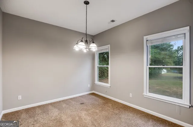 a view of a big room with windows and chandelier