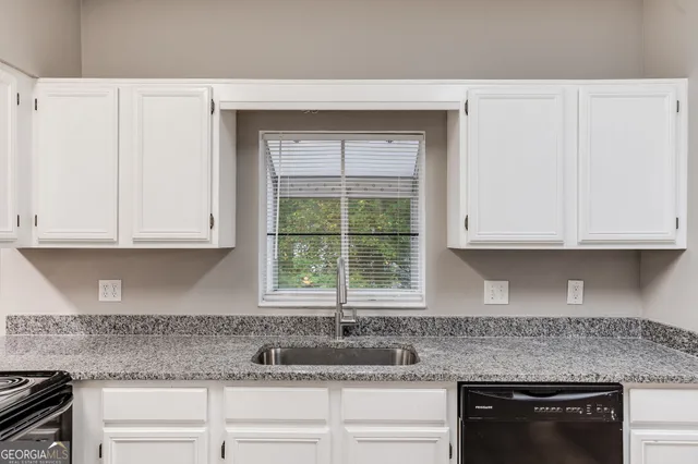a kitchen with granite countertop a sink and a stove