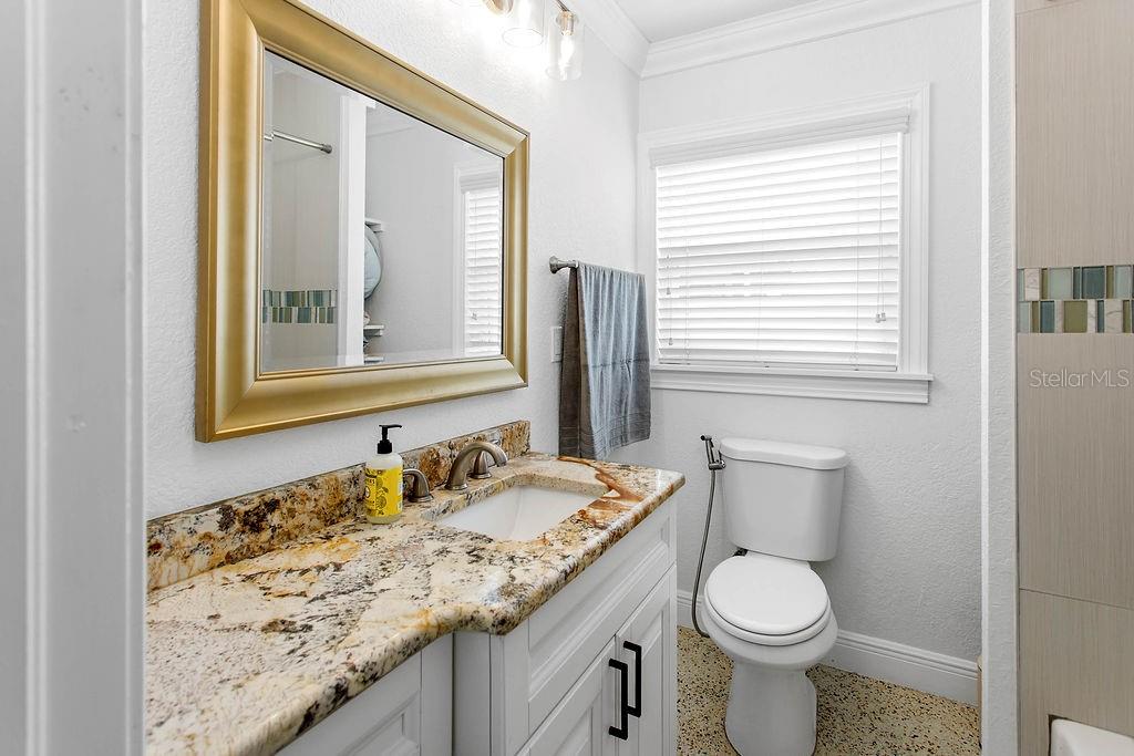 2909 West Dewey Street Tampa, FL 33607 - Photo 16 of 25 a bathroom with a granite countertop sink toilet and mirror