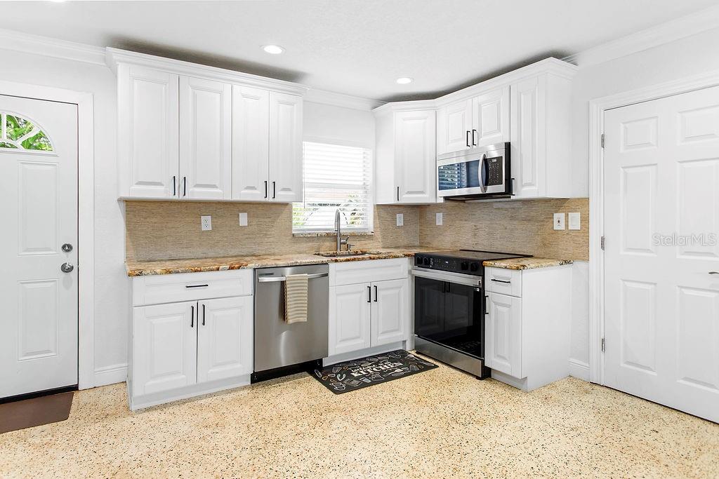 2909 West Dewey Street Tampa, FL 33607 - Photo 7 of 25 a kitchen with granite countertop white cabinets and white appliances