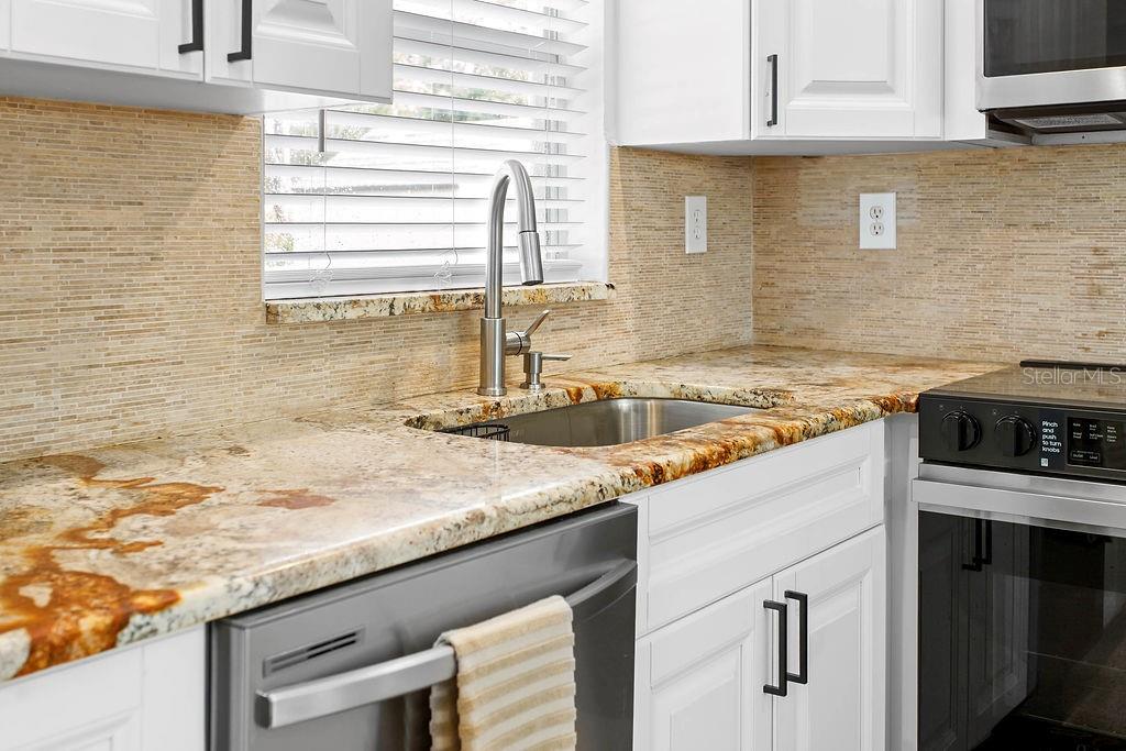 2909 West Dewey Street Tampa, FL 33607 - Photo 9 of 25 a kitchen with granite countertop a sink and a stove