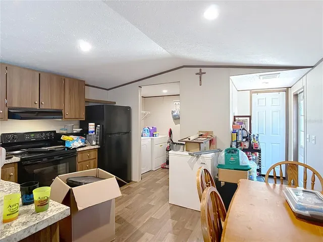 a kitchen with a refrigerator and a stove top oven