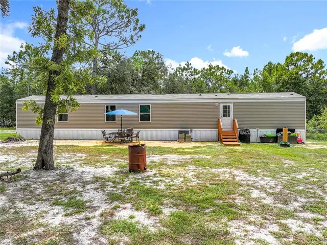 a backyard of a house with table and chairs