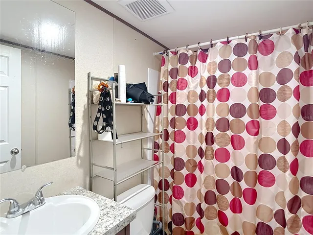 a bathroom with a sink toilet and mirror