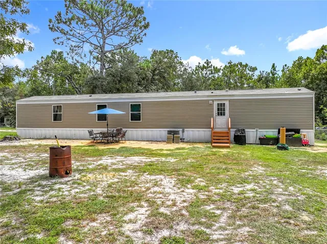 a backyard of a house with table and chairs