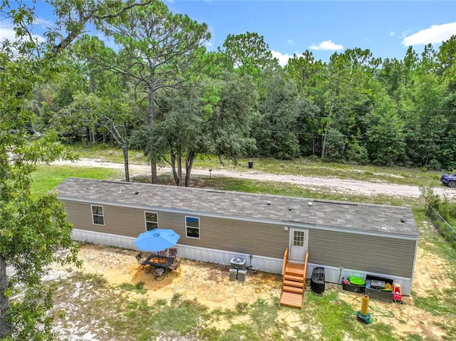 an aerial view of a house with a yard basket ball court and outdoor seating