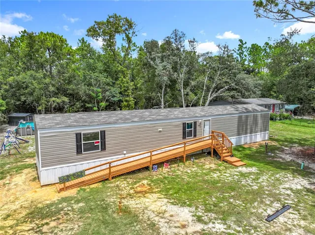 a backyard of a house with a yard and outdoor seating