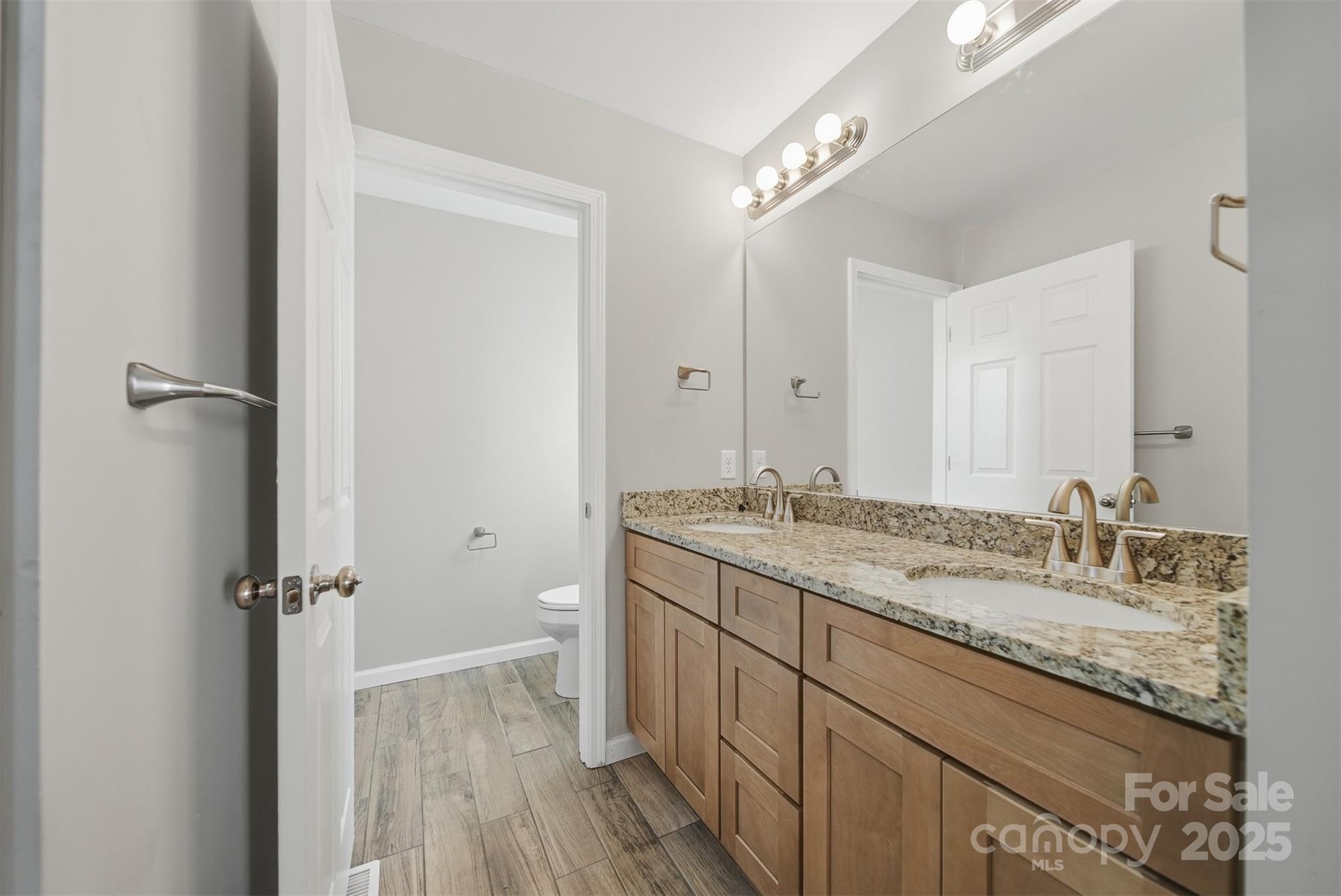 4951 Grace Chapel Road Granite Falls, NC 28630 - Photo 19 of 38 a bathroom with a granite countertop sink a mirror and a toilet