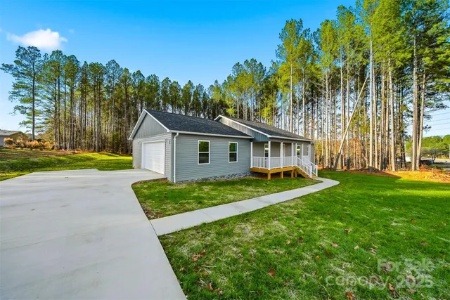 a view of house with backyard and trees
