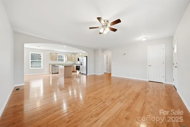 a view of empty room with wooden floor and window