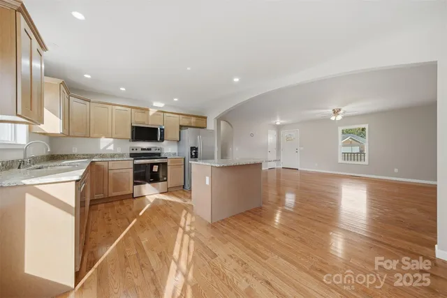 a kitchen with granite countertop a stove top oven and cabinets