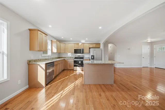 a kitchen with granite countertop a stove top oven and cabinets