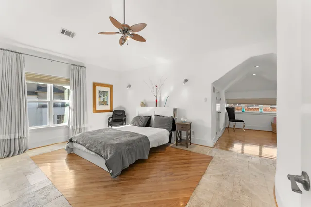a bedroom with a bed and wooden floor