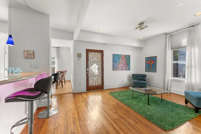 a living room with furniture and a wooden floor