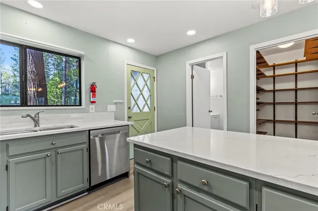 a dining hall with stainless steel appliances granite countertop a sink and wooden floor