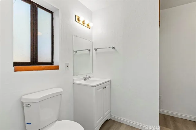 a bathroom with a toilet a sink a mirror and vanity