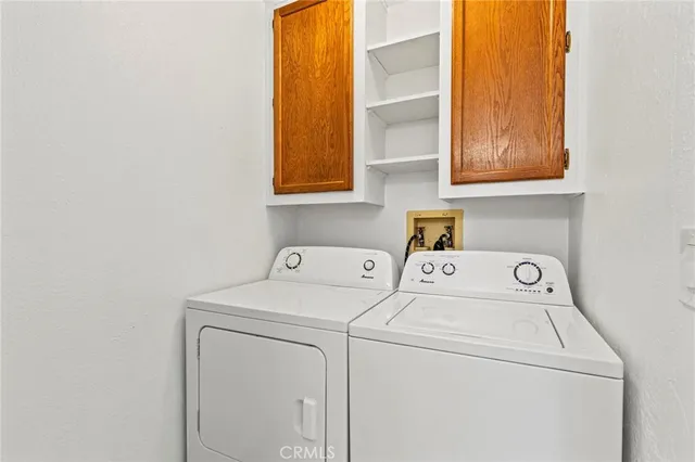 a view of an empty room with wooden floor and windows