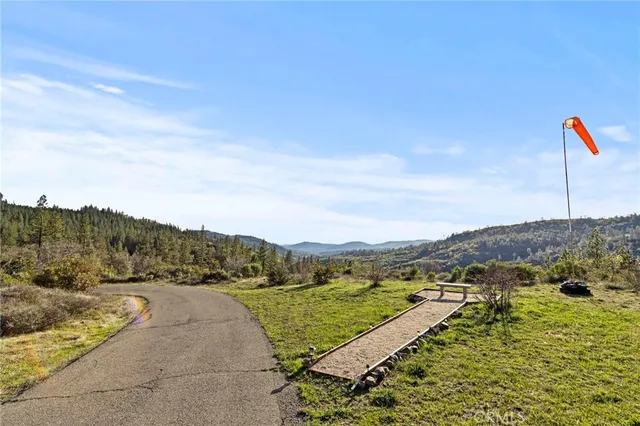 an aerial view of a house with a yard and mountain view in back