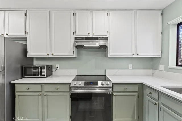 a kitchen with stainless steel appliances granite countertop a sink a stove and cabinets