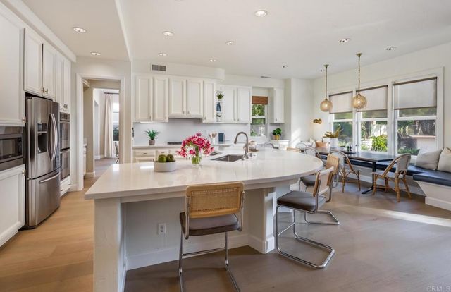 a kitchen with stainless steel appliances kitchen island granite countertop a dining table and chairs