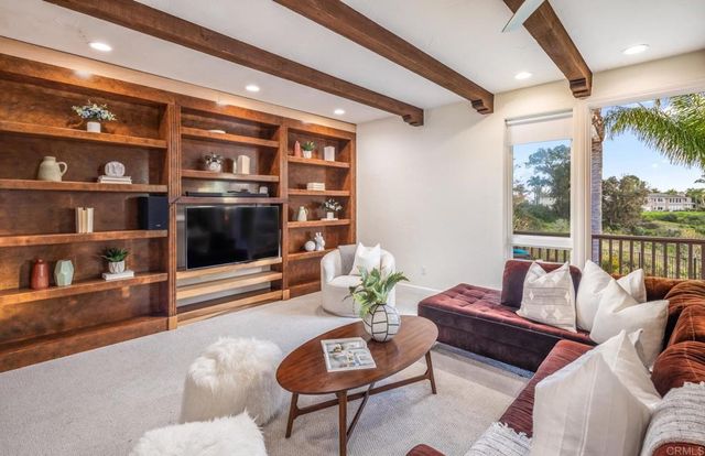 a living room with furniture a rug and a floor to ceiling window
