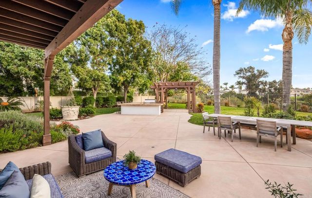 a view of a patio with couches and table and chairs and potted plants