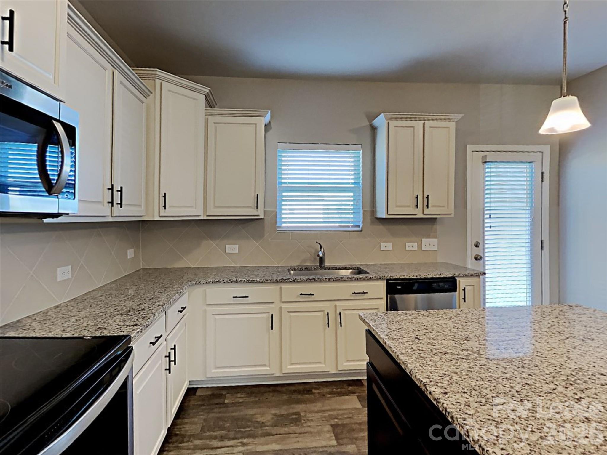 543 Contentment Drive Locust, NC 28097 - Photo 33 of 36 a kitchen with stainless steel appliances granite countertop a sink stove and cabinets