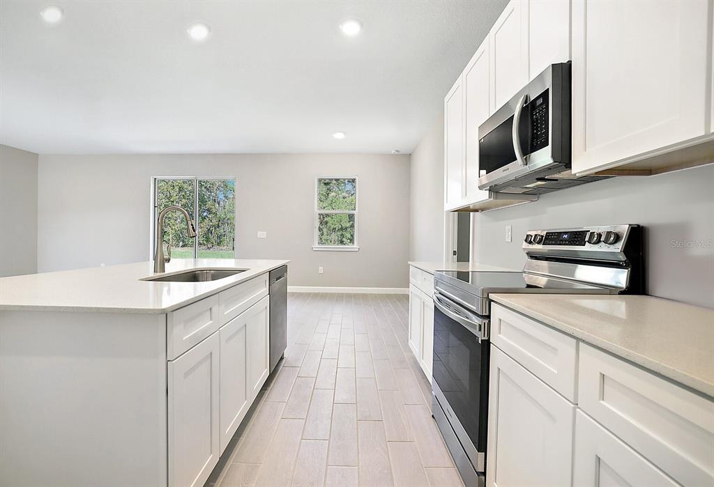 7348 Southwest 134th Street Ocala, FL 34473 - Photo 21 of 49 a kitchen with stainless steel appliances granite countertop a sink and a stove