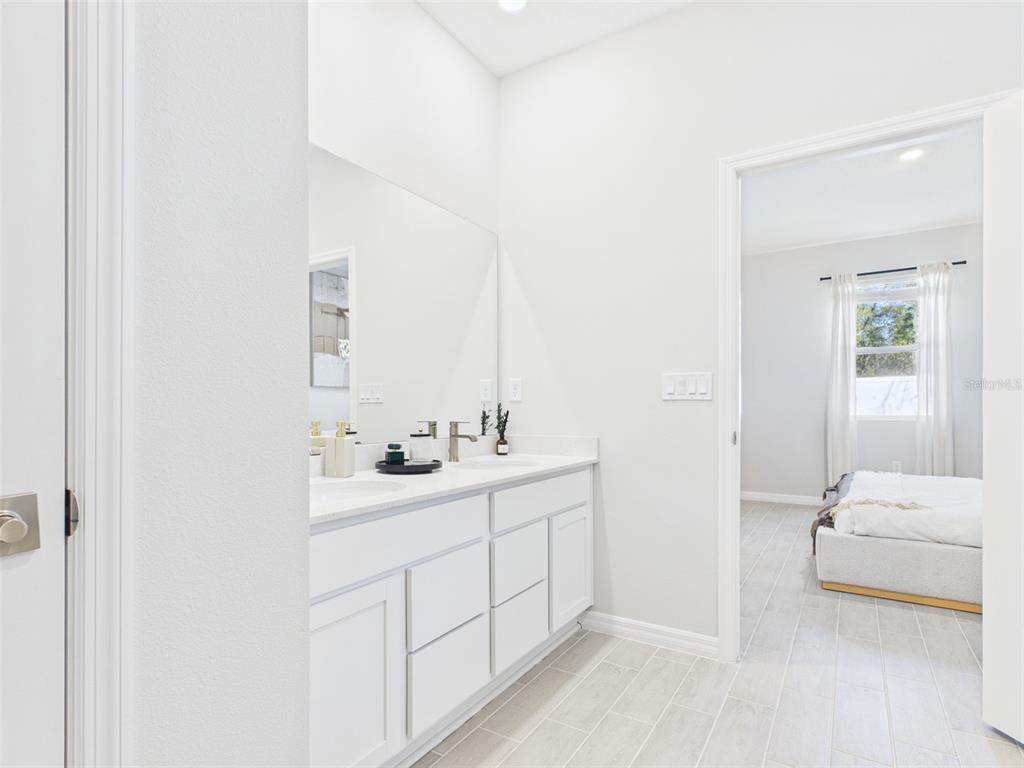 7348 Southwest 134th Street Ocala, FL 34473 - Photo 32 of 49 a en suite bathroom with a sink and a mirror