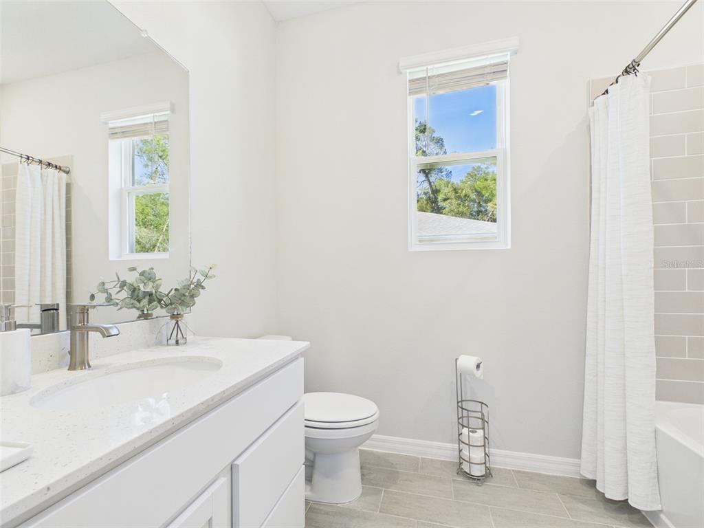 7348 Southwest 134th Street Ocala, FL 34473 - Photo 42 of 49 a bathroom with a granite countertop sink a toilet and a mirror
