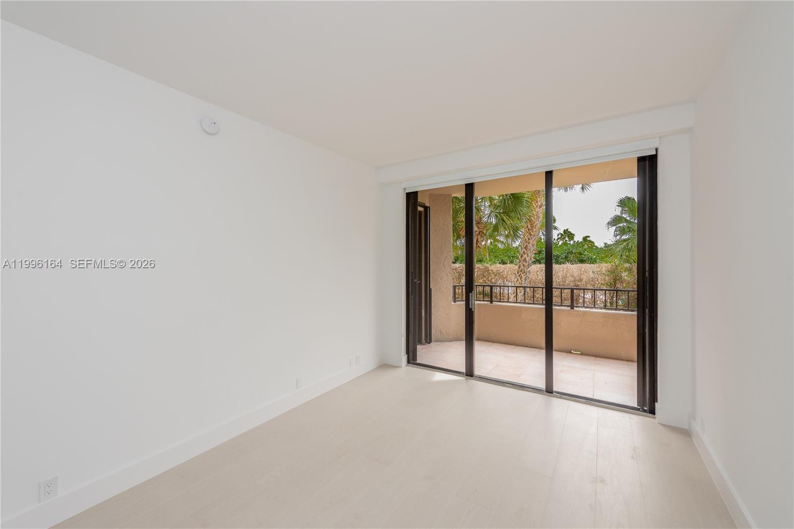 151 Crandon Boulevard, Unit 241 Key Biscayne, FL 33149 - Photo 21 of 28 an empty room with sliding glass door and garden view