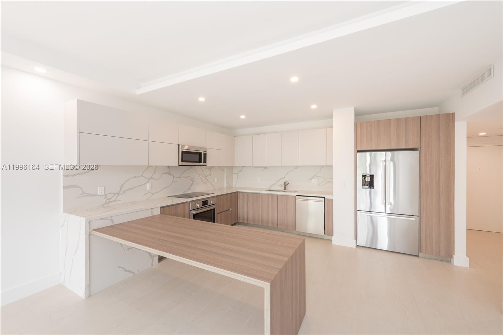 151 Crandon Boulevard, Unit 241 Key Biscayne, FL 33149 - Photo 4 of 28 a kitchen with a refrigerator sink and cabinets