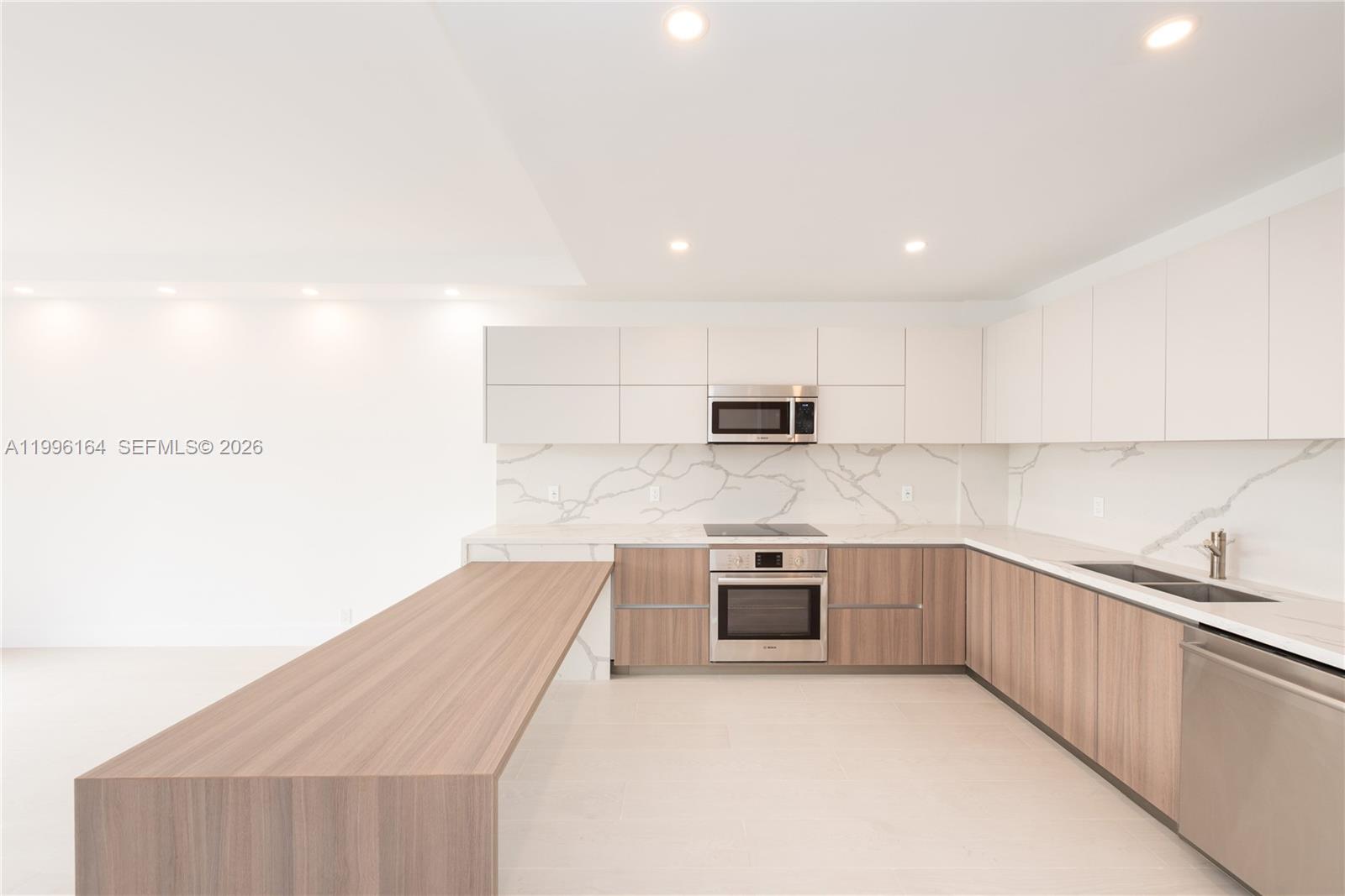 151 Crandon Boulevard, Unit 241 Key Biscayne, FL 33149 - Photo 5 of 28 a kitchen with stainless steel appliances granite countertop a sink and stove top oven
