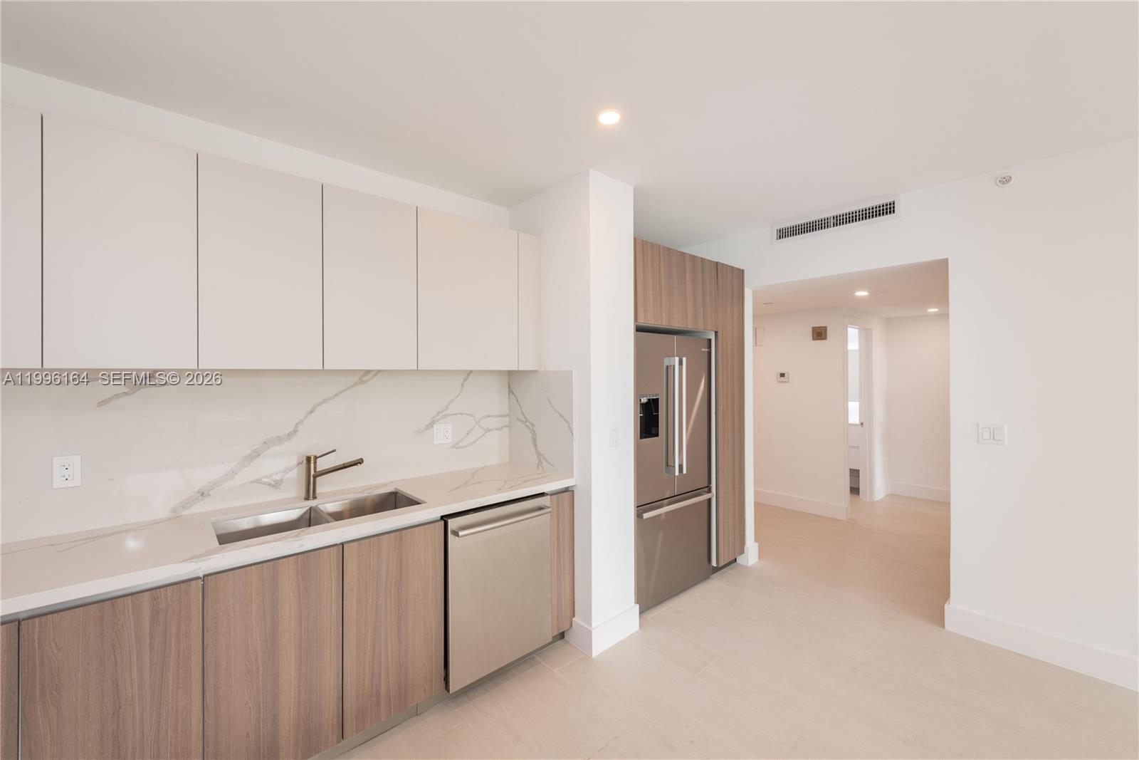 151 Crandon Boulevard, Unit 241 Key Biscayne, FL 33149 - Photo 7 of 28 a kitchen with white cabinets and refrigerator