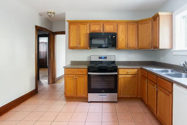 a kitchen with stainless steel appliances granite countertop a stove a sink and a microwave