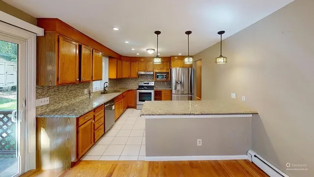 a kitchen with stainless steel appliances granite countertop a refrigerator a sink and a stove