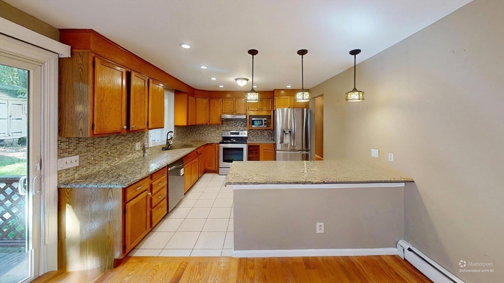 18 Cranston Circle Woburn, MA 01801 - Photo 3 of 19 a kitchen with stainless steel appliances granite countertop a refrigerator a sink and a stove
