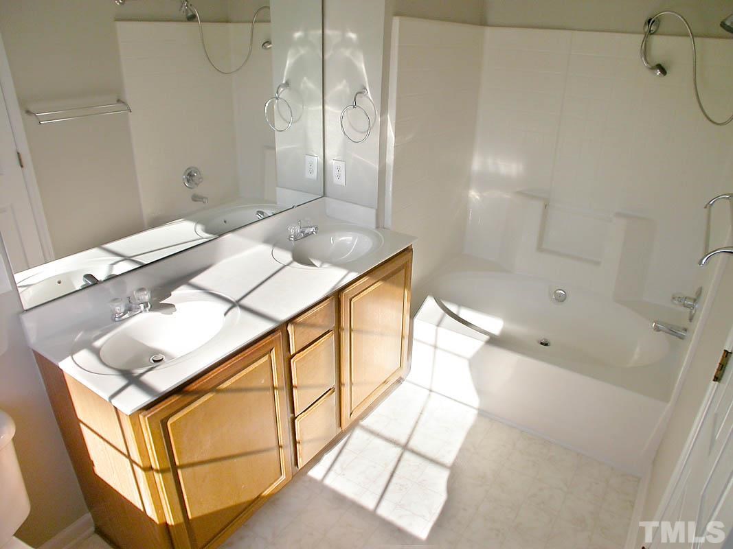 7347 Doverton Court Raleigh, NC 27615 - Photo 13 of 20 a bathroom with a bathtub sink and mirror