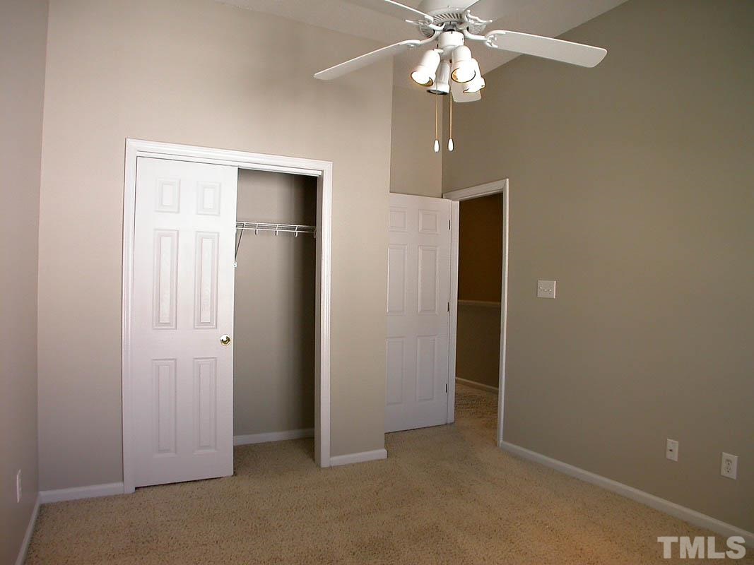 7347 Doverton Court Raleigh, NC 27615 - Photo 15 of 20 an empty room with closet and a chandelier fan