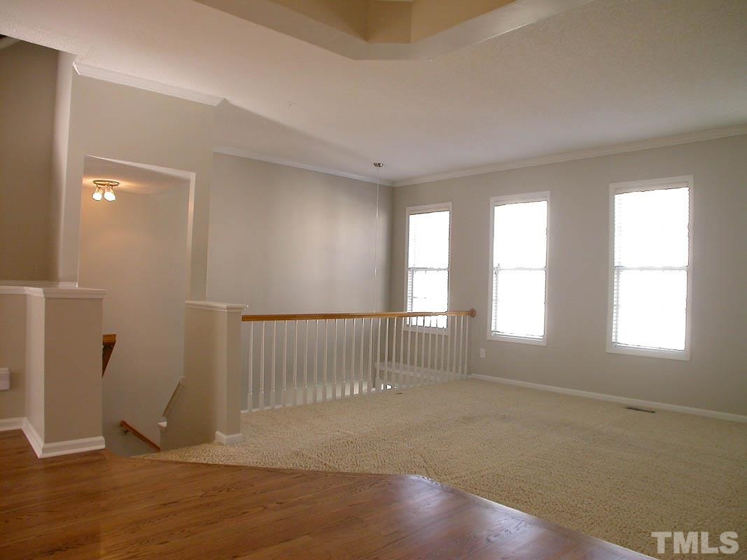 7347 Doverton Court Raleigh, NC 27615 - Photo 3 of 20 wooden floor in an empty room with a window