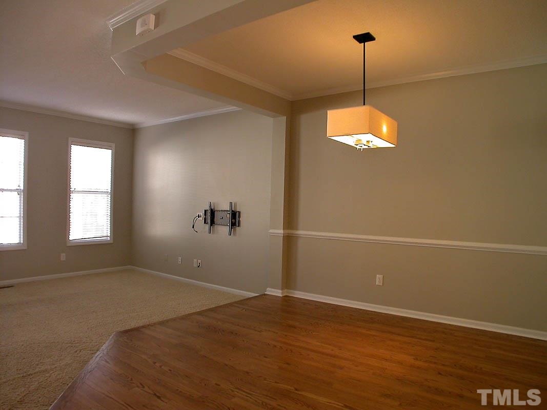 7347 Doverton Court Raleigh, NC 27615 - Photo 4 of 20 an empty room with window and hardwood floor