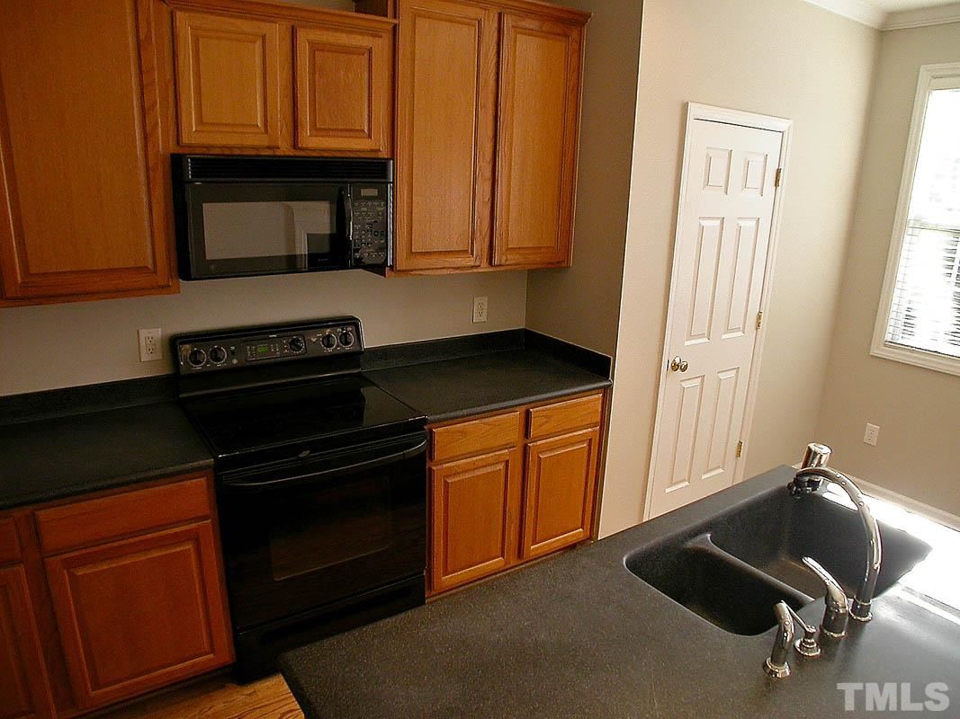 7347 Doverton Court Raleigh, NC 27615 - Photo 8 of 20 a kitchen with granite countertop a stove and a microwave