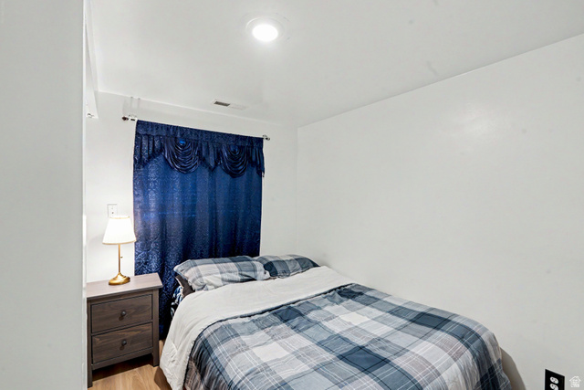 3689 Lasso Loop Circle Magna, UT 84044 - Photo 13 of 26 3rd Bedroom downstairs with recessed ceiling lighting, wood-finish flooring, and a window featuring window treatments