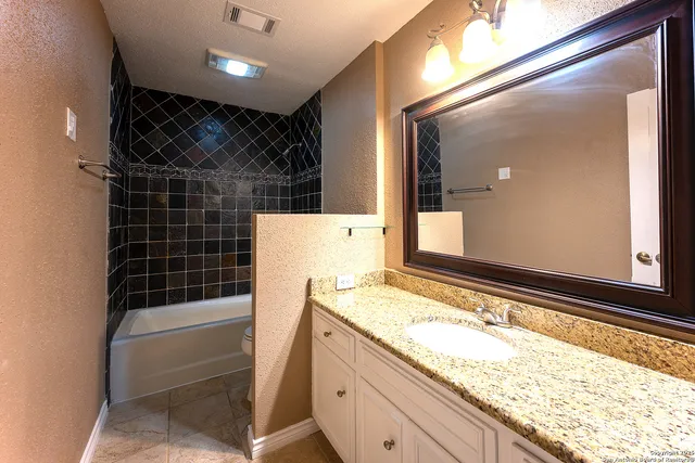 a bathroom with a granite countertop sink and a mirror