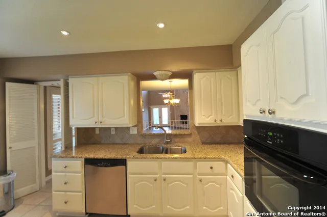 a kitchen with granite countertop a sink and cabinets